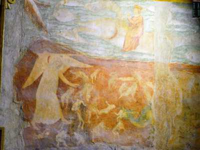 Dall�altro un angelo con le mani e la veste color del fuoco sospinge i dannati tra le spire del demonio